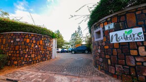 A stone wall with a sign reading "Nature Kigali" and a street sign indicating "KG 515 St 9". - Nature Kigali (Kigali)