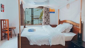 Une chambre à coucher avec un lit à baldaquin, une table de chevet en bois, une chaise et une fenêtre donnant sur un paysage verdoyant.