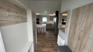 Un pasillo estrecho que desemboca en una zona de cocina.