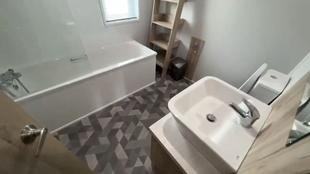 A bathroom with a bathtub, a sink, and a shower.