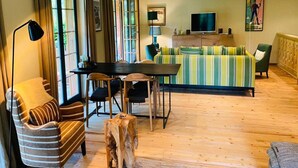 Un salon chaleureux avec un canapé à rayures, une table basse en bois et un téléviseur.