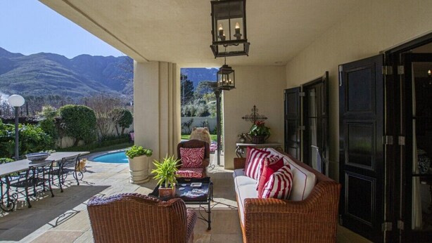 A covered patio with wicker furniture, a pool, and a mountain view. - Kilima Franschhoek  (Franschhoek)