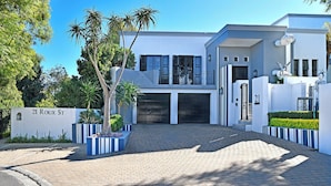 A modern two-story house with a driveway, garage, and a sign reading "21 Roux St." - Kilima Franschhoek  (Franschhoek)