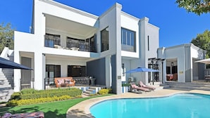 A modern two-story house with a swimming pool, outdoor seating, and a well-maintained garden. - Kilima Franschhoek  (Franschhoek)