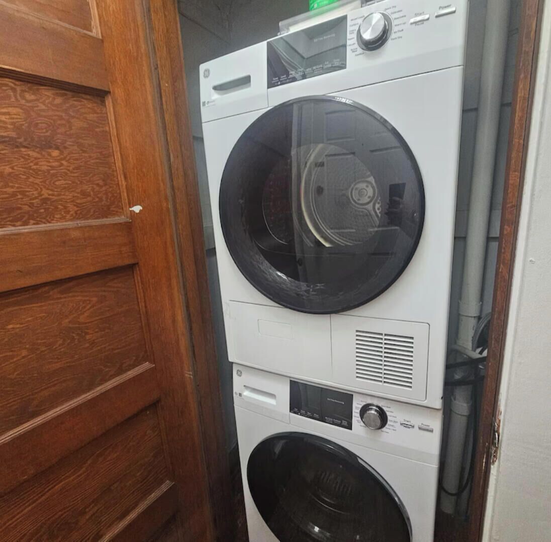 Eine übereinander angeordnete Waschmaschine und ein Trockner in einem Waschraum.