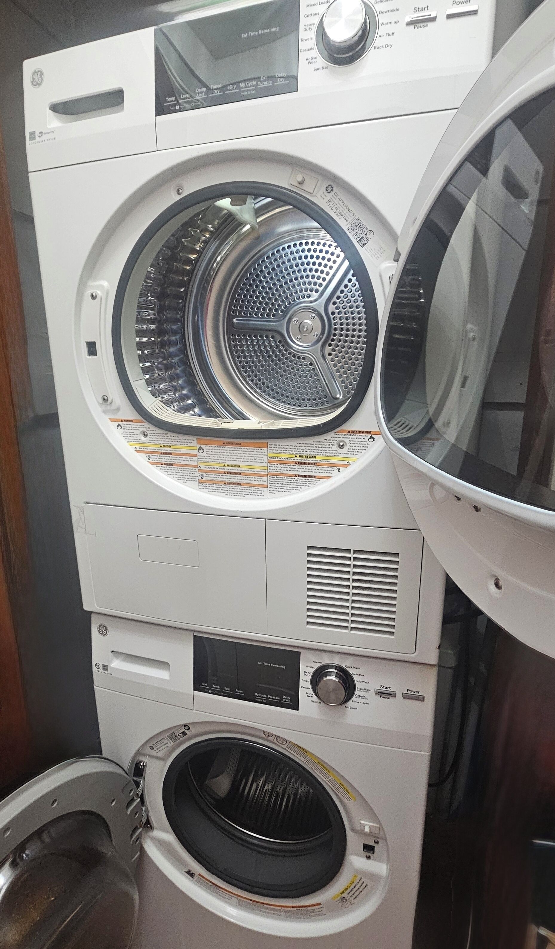 Una lavadora y secadora apiladas, con un panel de control, una lavadora de carga frontal y una secadora de carga superior.
