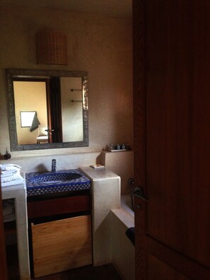 A bathroom with a sink, mirror, and a wooden cabinet. - Dar Talmout (Bine el Ouidane)