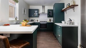 A compact kitchen with dark cabinets, a white countertop, and a central island.