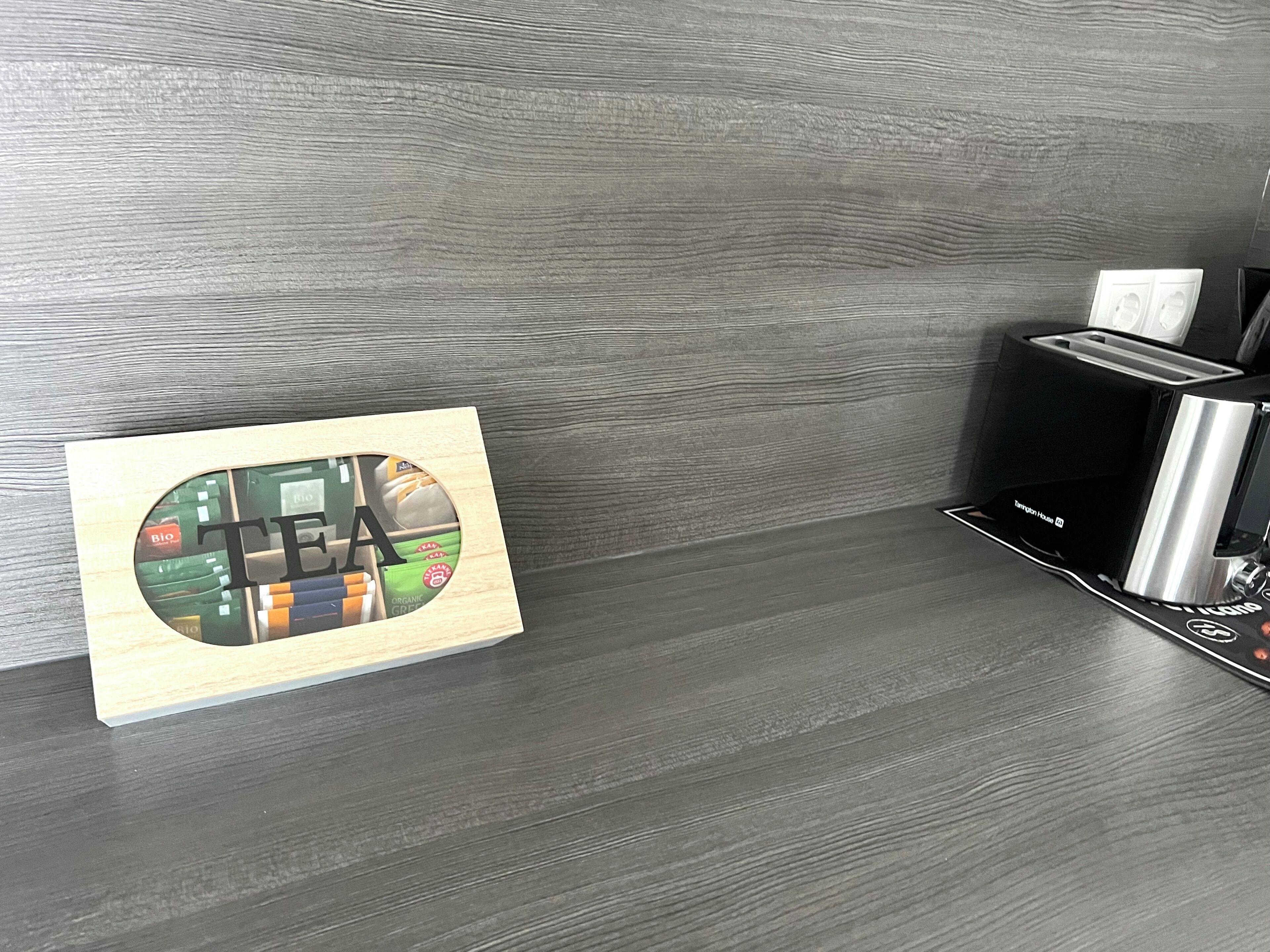 A modern kitchen with a wooden countertop, a coffee machine, and a toaster.