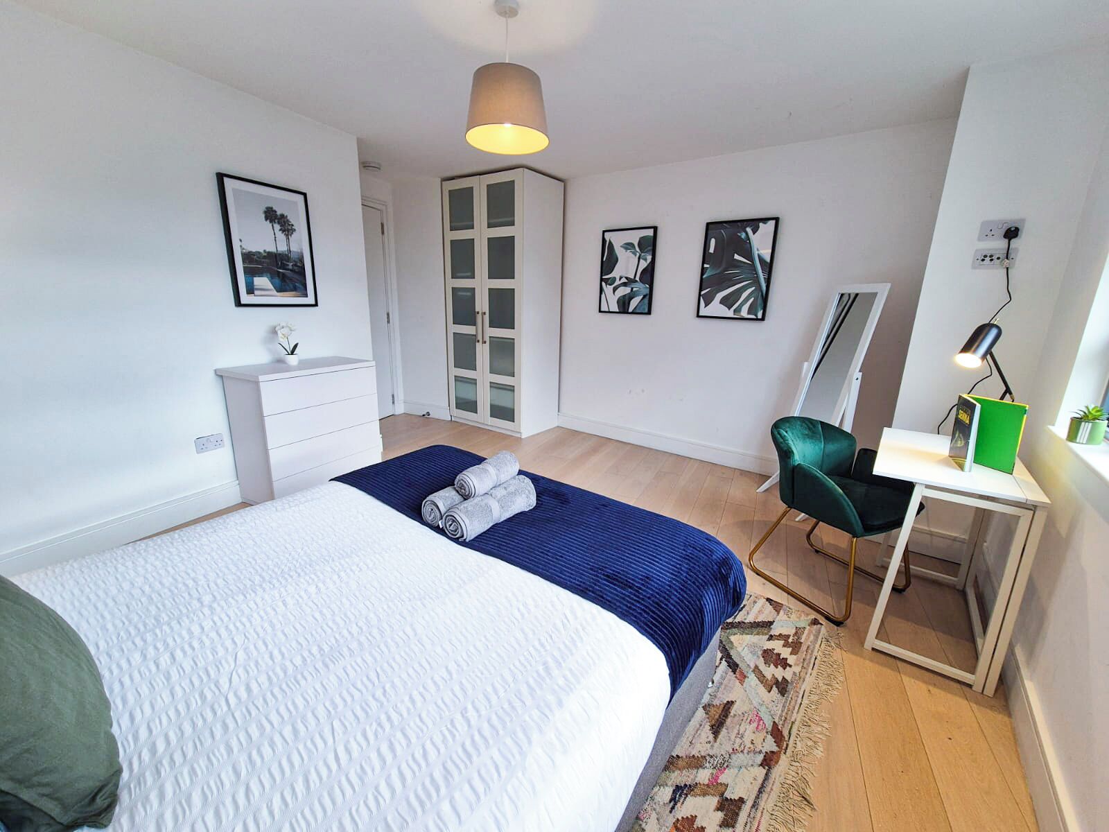 Une chambre à coucher avec un lit, un bureau, une chaise et une armoire.