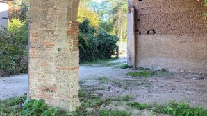 Un antiguo puente de piedra con un muro de ladrillos debajo.