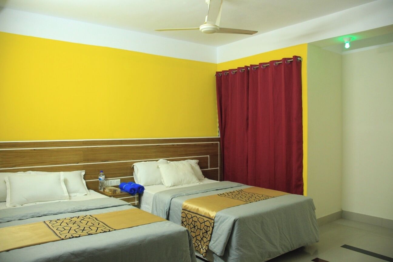 A hotel room with two beds, a wooden headboard, a red curtain, and a ceiling fan.