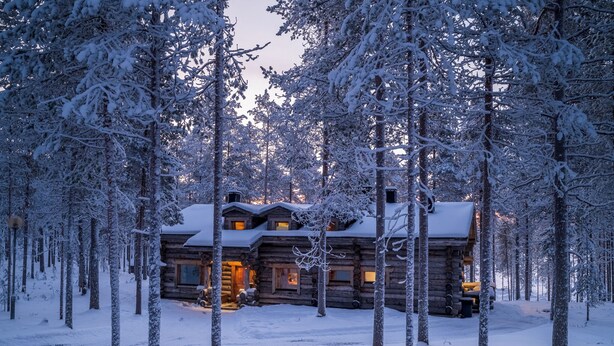 A log cabin surrounded by snow-covered trees. - Oivangin Lomakartano (Kuusamo)