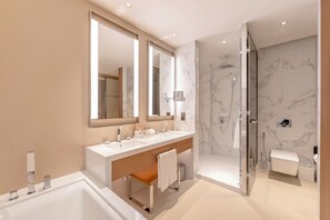 A modern bathroom with two sinks, a large mirror, a shower, and marble walls. - Address Opera Residences Burj View (Dubai)