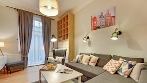 Una sala de estar moderna con un sofá, una mesa de centro, una silla y una estantería.