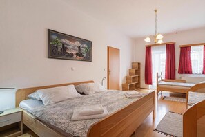 Ein Schlafzimmer mit Bett, Schreibtisch, Stuhl, Kleiderschrank und einem Bild an der Wand.