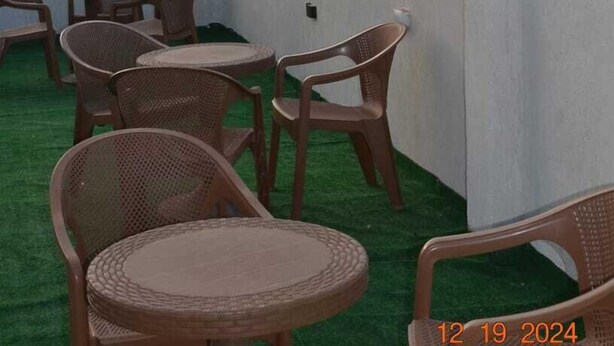 A rooftop terrace with wicker furniture and a view of the pyramids. - Pyramids Terrace Hostel (Giza)