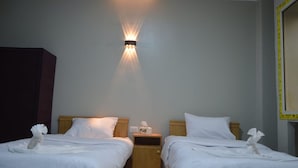 A hotel room with two beds, a nightstand with a lamp, and a wall-mounted light fixture. - Pyramids Terrace Hostel (Giza)
