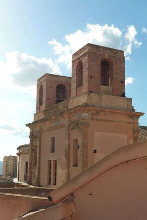 A historic building with a bell tower, arched windows, and a balcony. - OIKIA AUTOMATIC ROOMS (Agrigento)
