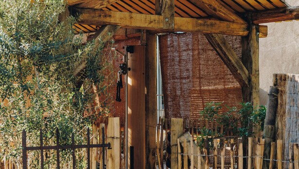 A rustic wooden structure with a sloped roof, a wooden gate, and a large pot in the foreground. - Case di Pigna magnificent recent VILLA 2 to 6 pers private swimming pool near Algajola (pigna)