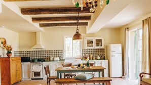A cozy kitchen with a wooden table, chairs, and a hanging light fixture. - Case di Pigna magnificent recent VILLA 2 to 6 pers private swimming pool near Algajola (pigna)