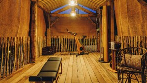 A wooden room with a high ceiling, a wooden bench, a chair, and a massage table. - Case di Pigna magnificent recent VILLA 2 to 6 pers private swimming pool near Algajola (pigna)