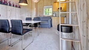 A cabin interior with a dining area, a kitchenette, and a loft bed. - 4 Person Holiday Park Home in Jelling (Jelling)