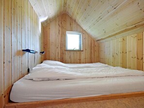 A single bed in a room with wooden walls and a sloped ceiling. - 4 Person Holiday Park Home in Jelling (Jelling)