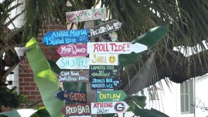 A collection of colorful directional signs with various destinations and distances. - Completely Renovated Gulf Front Home with Private Pool and Panoramic Views! (Santa Rosa Beach)