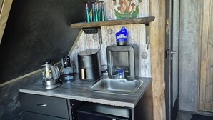 Eine kleine Küche mit Spüle, Kaffeemaschine, Mixer und einer Samsung-Mikrowelle.