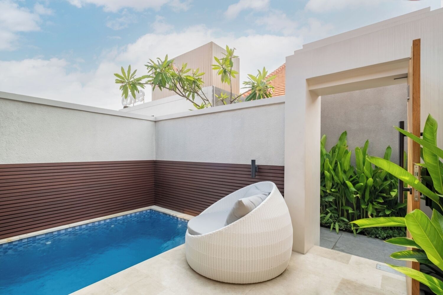 Uma área de piscina moderna ao ar livre, com espaço de estar integrado e vista dos edifícios circundantes.