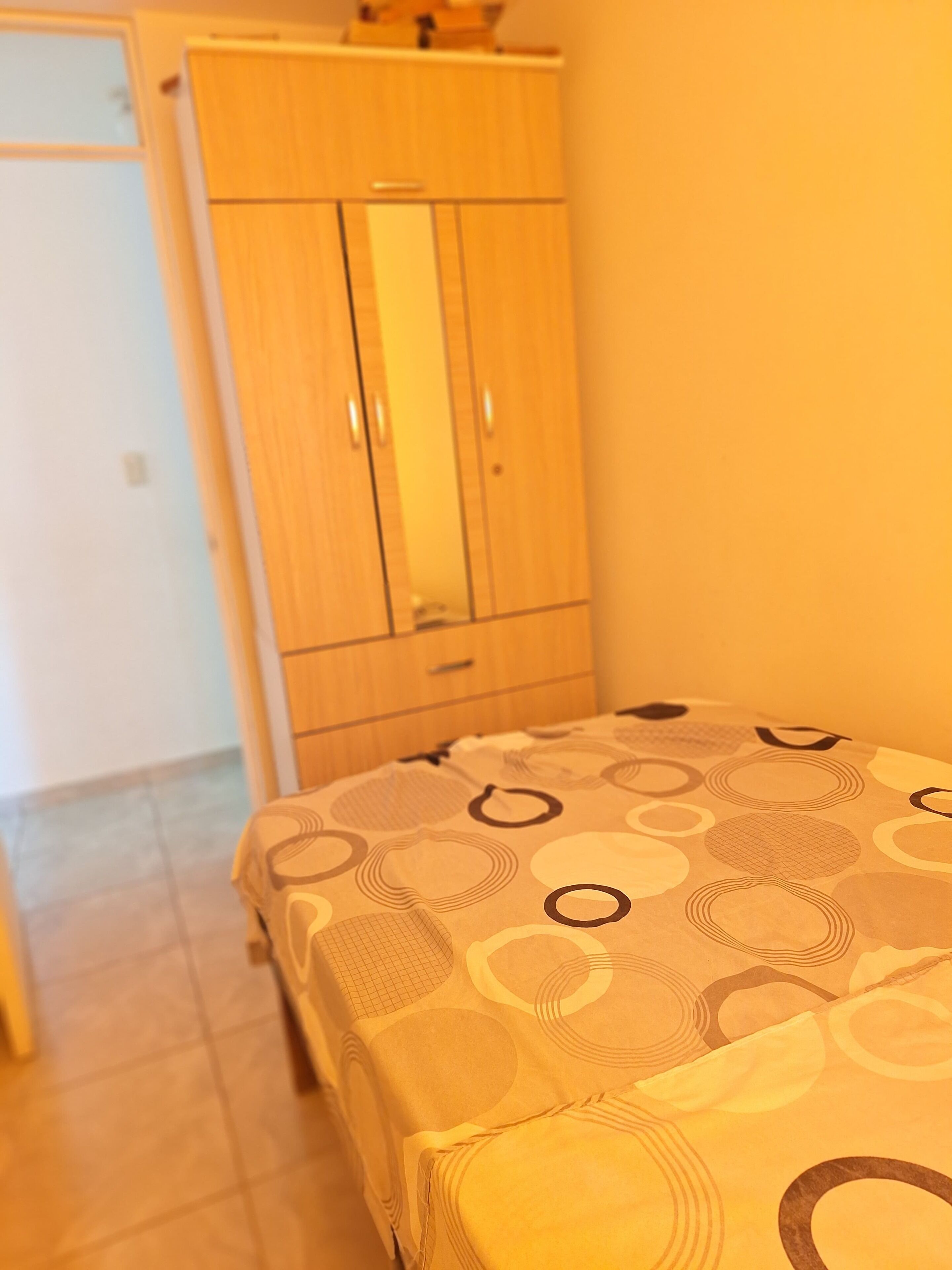 Un dormitorio con cama, armario y puerta.
