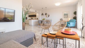 A modern living room with a sofa, two chairs, a dining table, and a kitchen in the background. - Calahonda Elegance With Pool And Sea View (Mijas)