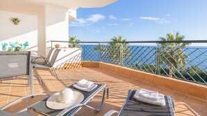 A balcony with two sun loungers, a table with chairs, and a view of the sea. - Mi Capricho Beach Front sea View Pool (Mijas)