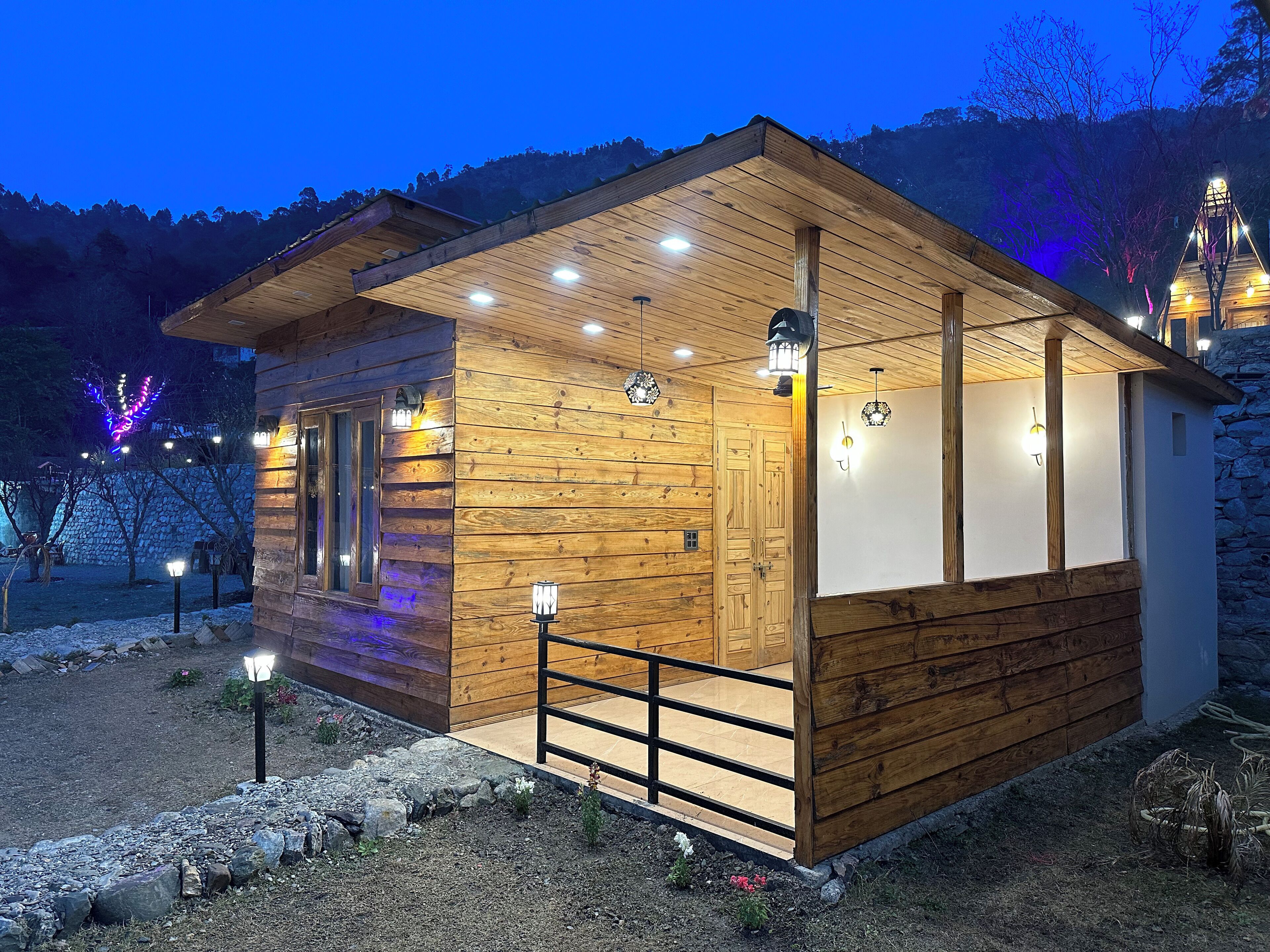 Una baita in legno con un balcone e diverse luci.