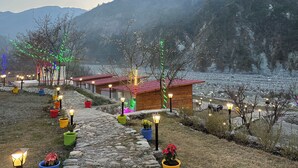 Eine rustikale Lodge mit einem rotem Chalet, umgeben von Topfpflanzen und Außenbeleuchtung.