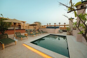 Piscine extérieure, parasols de plage, chaises longues