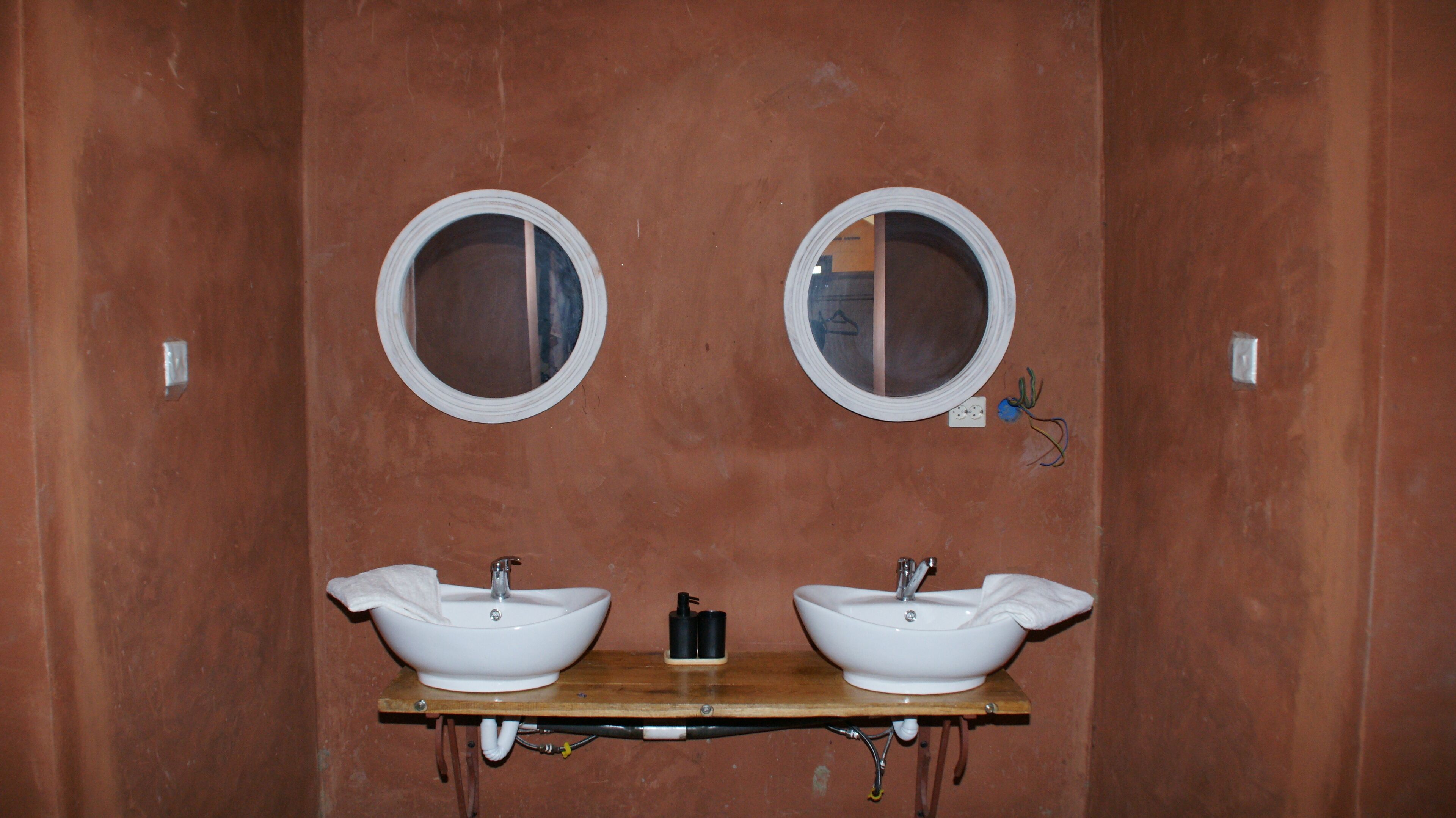 Une salle de bain avec deux lavabos, chacun étant surmonté d’un miroir.