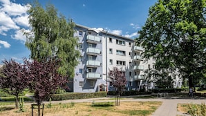 A multi-story residential building with balconies, surrounded by trees and a well-maintained lawn. - Apartamenty Sun & Snow Kasprowicza Warszawa (Warsaw)