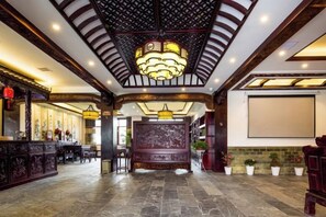 A lobby with a reception desk, seating area, and a large screen. - Siximingyuan in Wuyuan (Wuyuan)