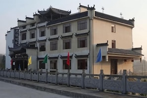 A traditional building with multiple floors, a balcony, and a flag in front. - Siximingyuan in Wuyuan (Wuyuan)