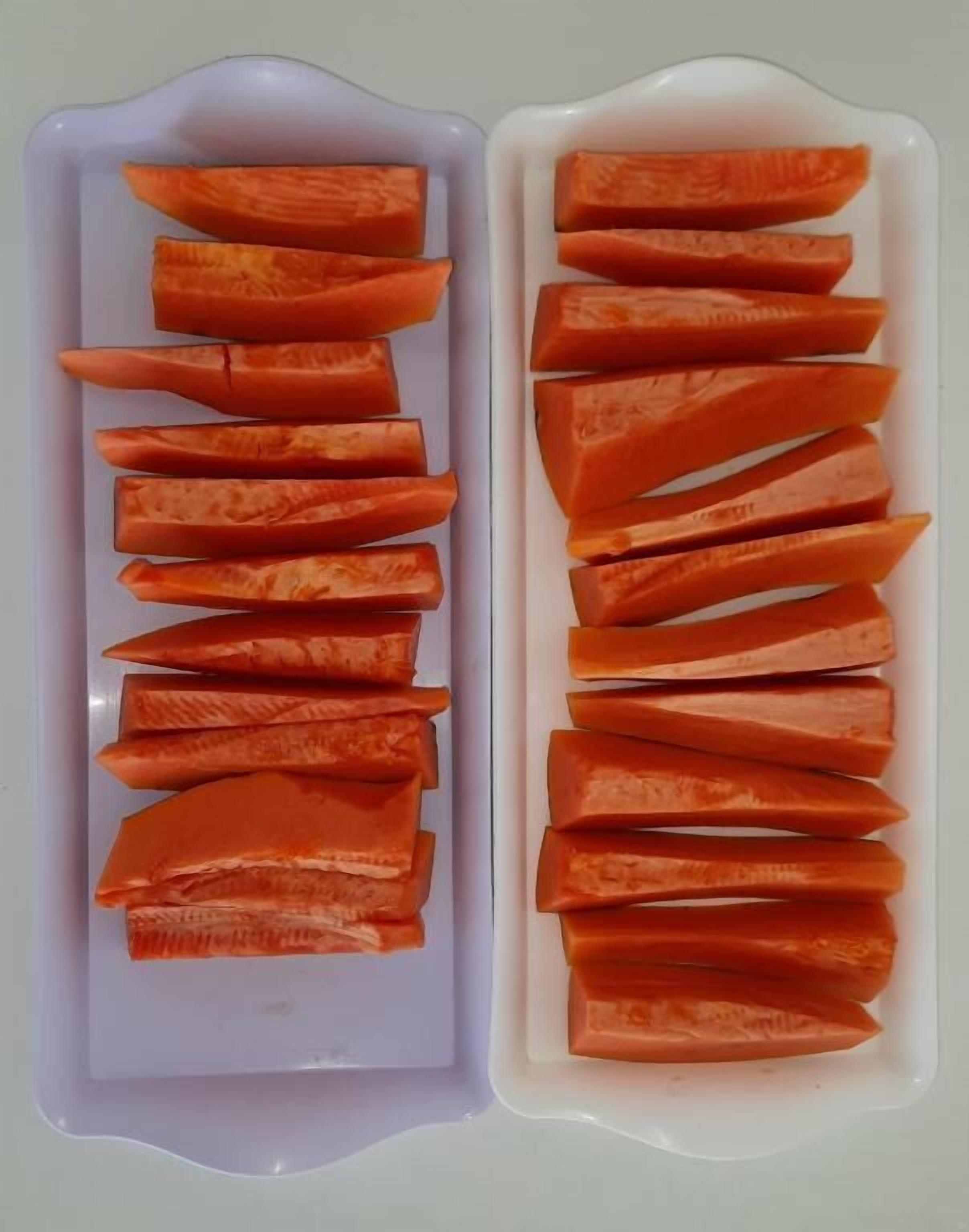 Two white trays with orange slices arranged in rows.