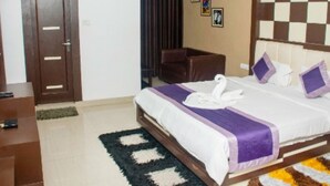 Una habitación de hotel con una cama, una silla, una puerta y un diseño de pared a cuadros.