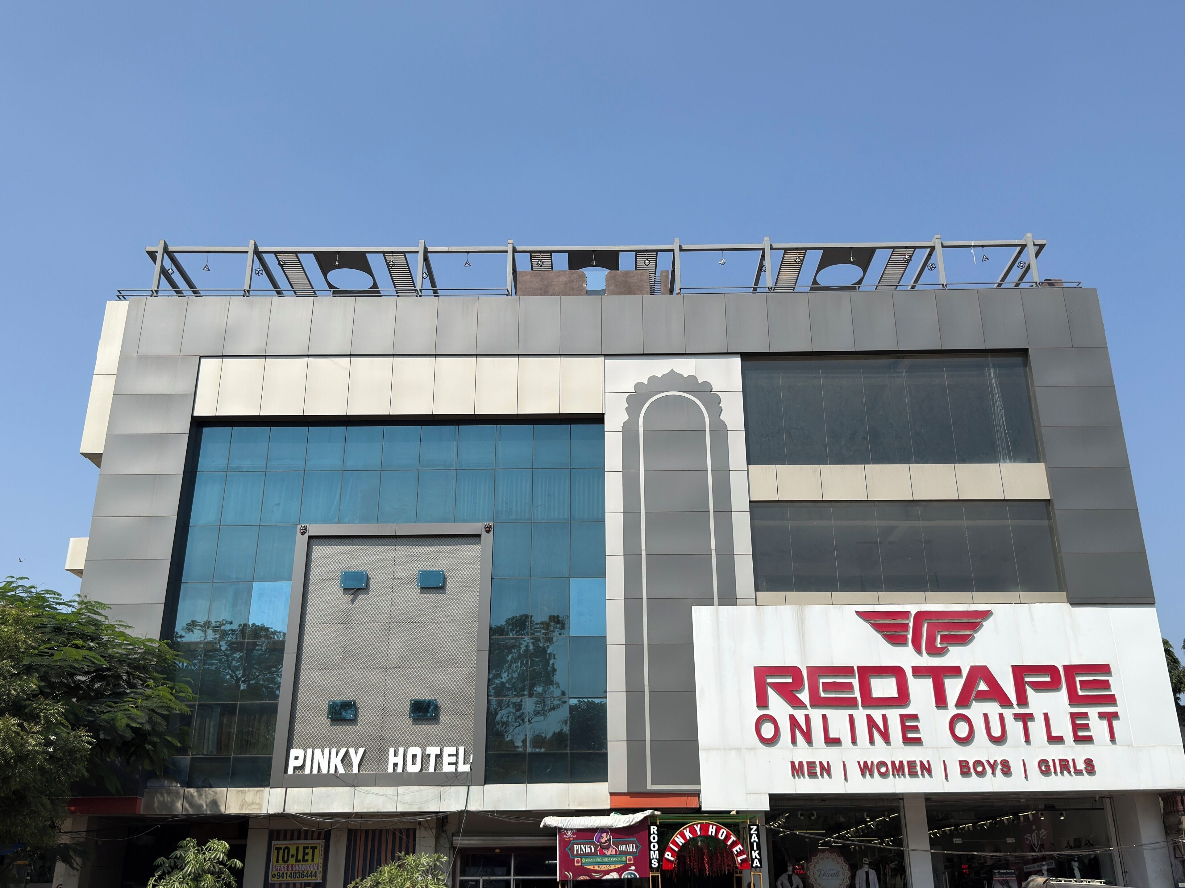 Un hotel con un punto de venta Redtape Online y un letrero Pinky Hotel.