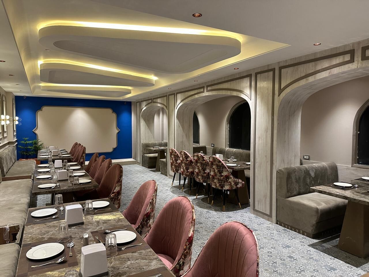 A conference room with a long table, multiple chairs, and a separate seating area with sofas.