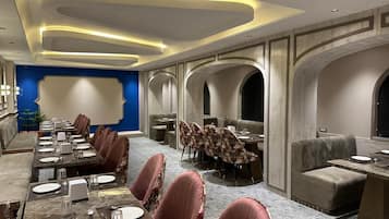 A conference room with a long table, multiple chairs, and a separate seating area with sofas.