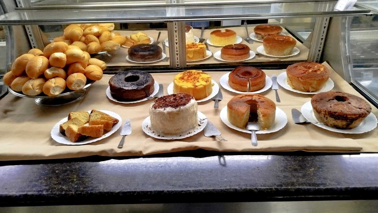 Vitrine de uma padaria com diversos bolos e doces.