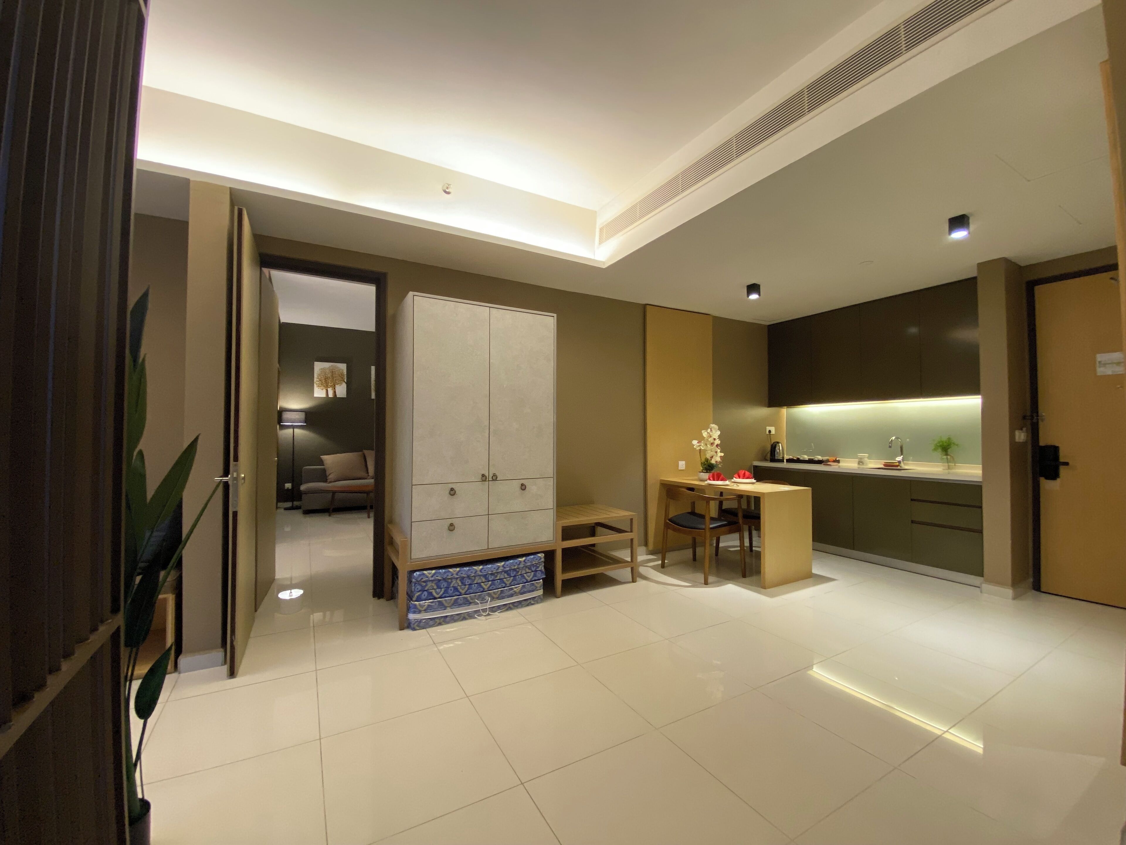 Een moderne hotelkamer met een ruime kledingkast, een eethoek en een kitchenette.