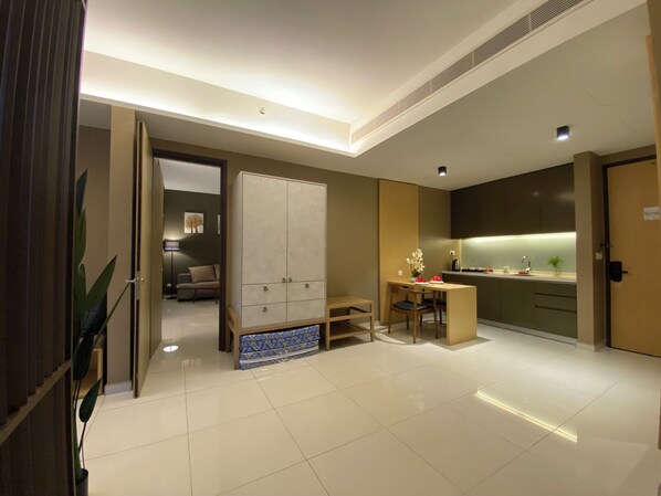 Una habitación de hotel moderna con un armario grande, una zona de comedor y una kitchenette.