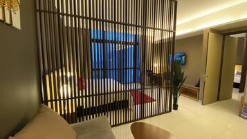 A modern living room with a sofa, a TV, and a decorative partition.